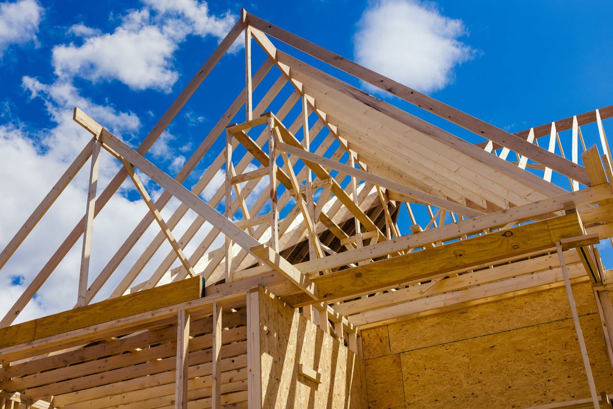 Wooden roof trusses and framing under construction on a residential home job site