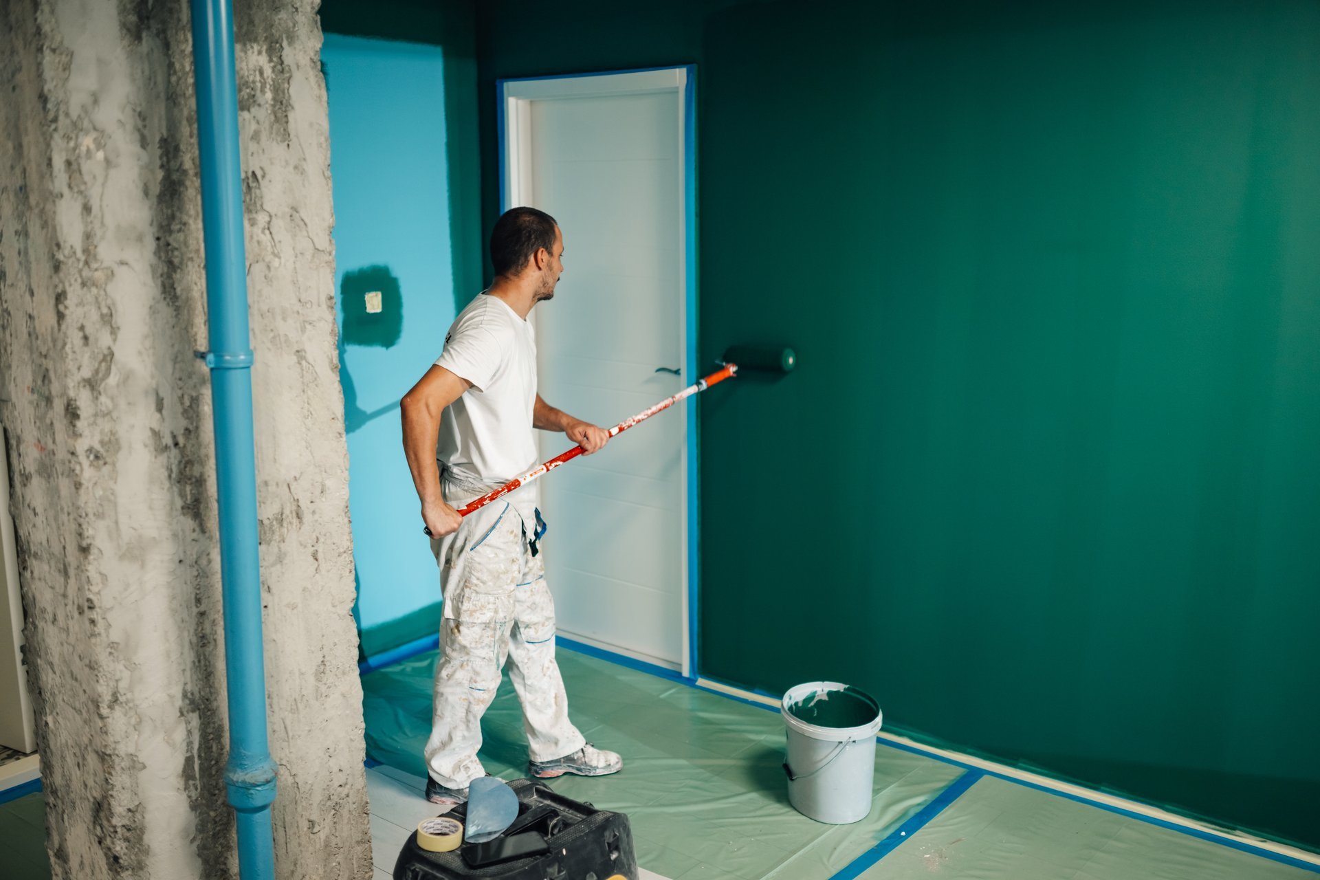 Professional painter applying fresh paint to room interior