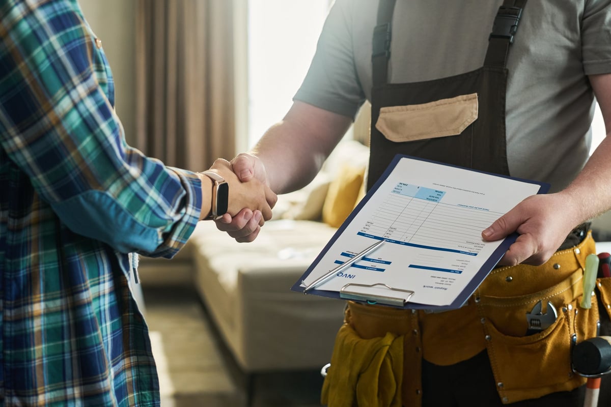 Contractor and homeowner shaking hands during construction planning meeting