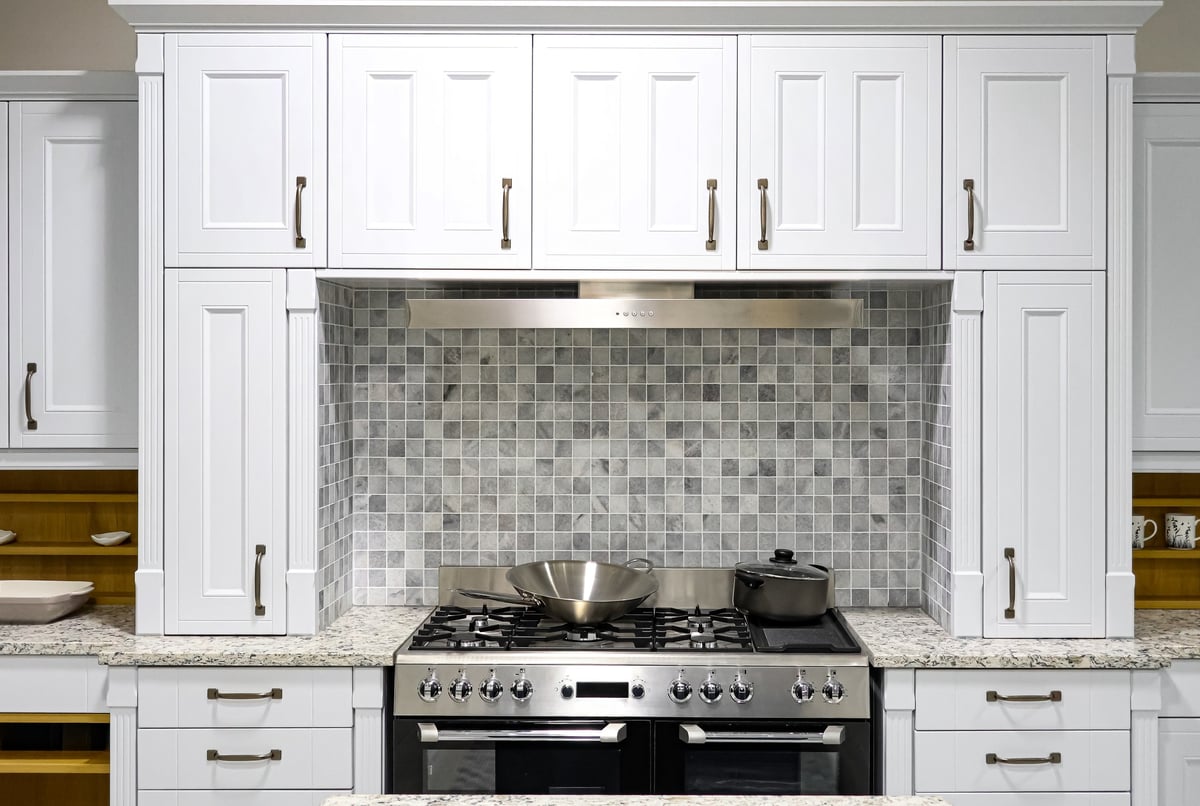 Modern white kitchen with granite countertops and stainless steel appliances