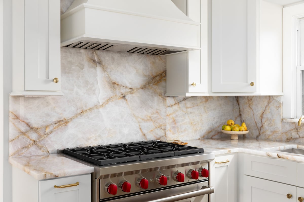 Kitchen with white cabinetry, marble countertop and range hood in a Bradenton home