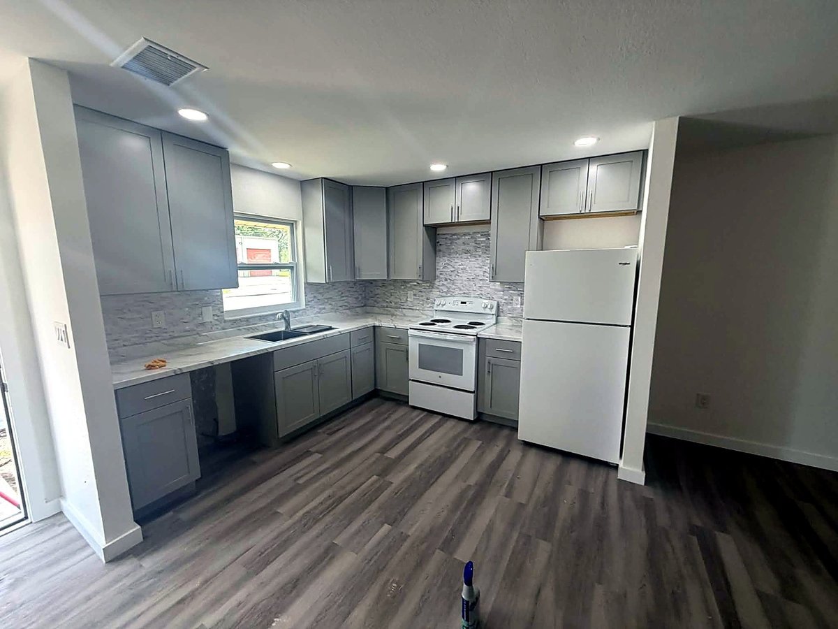 Bradenton kitchen update with gray cabinets, mosaic backsplash and wood-look luxury vinyl plank flooring.