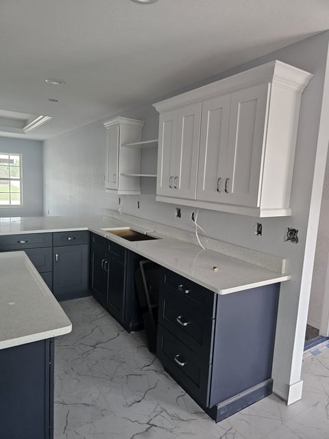Kitchen island with dark shaker cabinetry and light countertops.