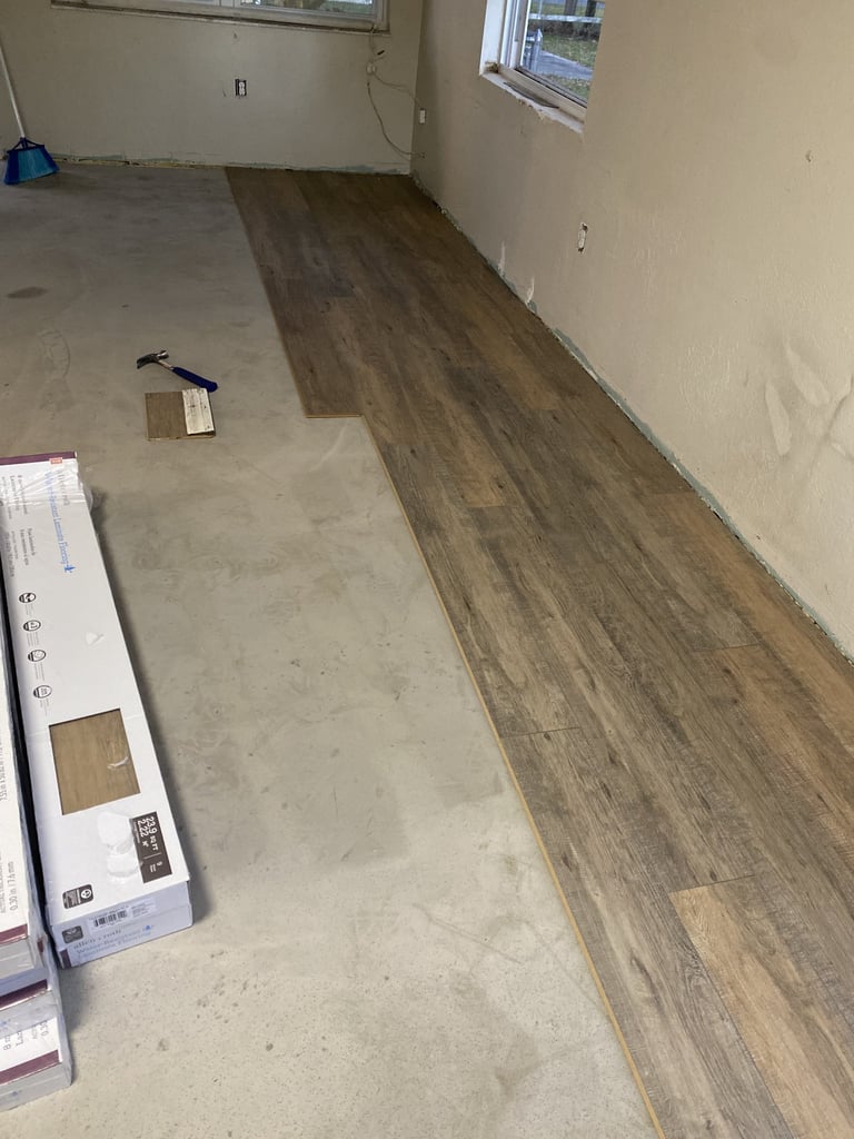 Partially installed wood-look plank flooring beside exposed subfloor in Bradenton.
