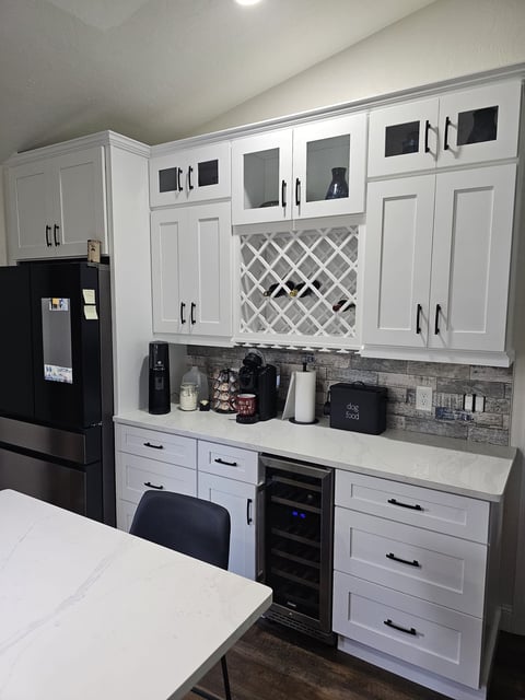 Built-in gray cabinetry with dark countertop and under-counter beverage refrigerators.