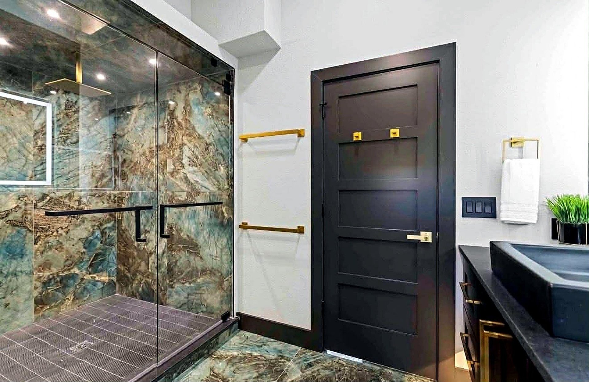Siesta Key walk-in shower with blue-green stone-look surfaces and glass enclosure