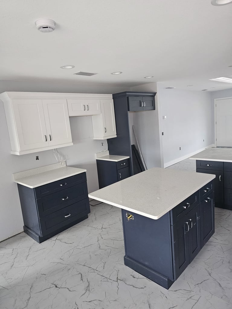 Kitchen remodel with two-tone cabinets and marble-look tile flooring.
