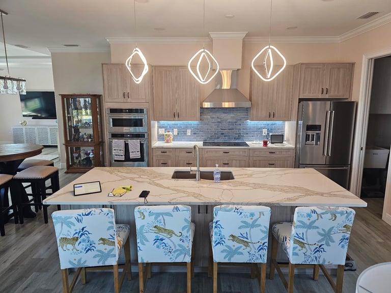 Bradenton Beach coastal kitchen remodel with wood-grain cabinetry, blue tile backsplash and a large center island