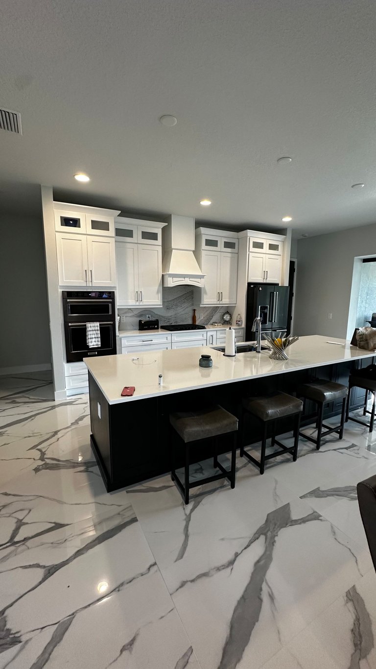 Dark kitchen island with a light countertop, undermount sink and bar seating in Nokomis.