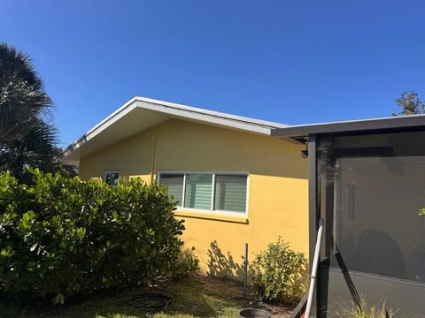 After: Completed yellow window elevation beneath the gable beside the screened enclosure.