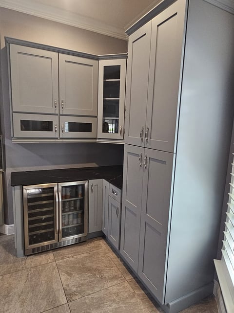 White kitchen cabinetry with pantry storage, stainless steel range and microwave.