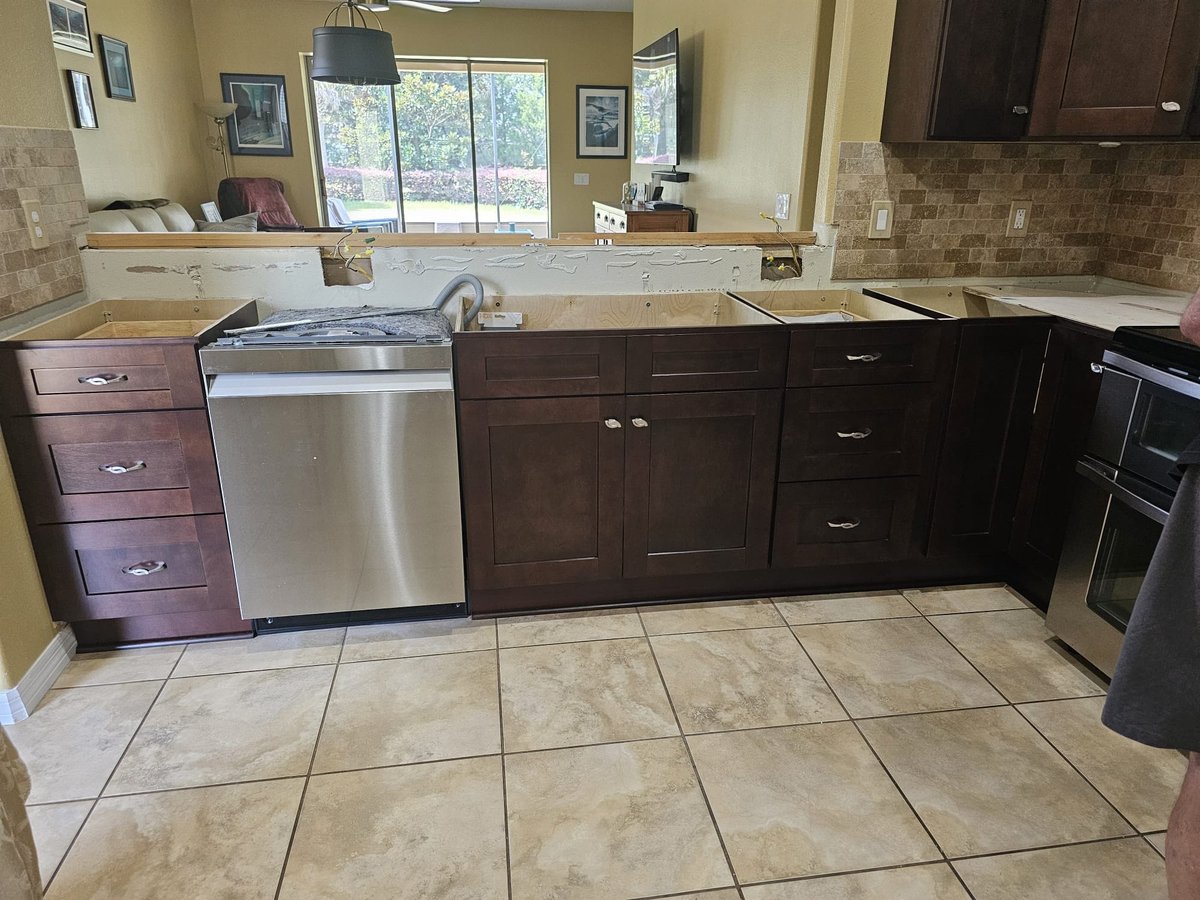 White built-in kitchen cabinetry with a refrigerator, integrated bottle storage and beverage station cabinetry