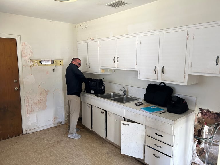 Original Bradenton kitchen with older white cabinetry and a double-basin sink before renovation.